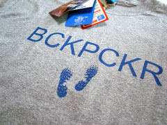 「slou」（スロウ）の「BCKPCR」（バックパッカー）Tシャツ